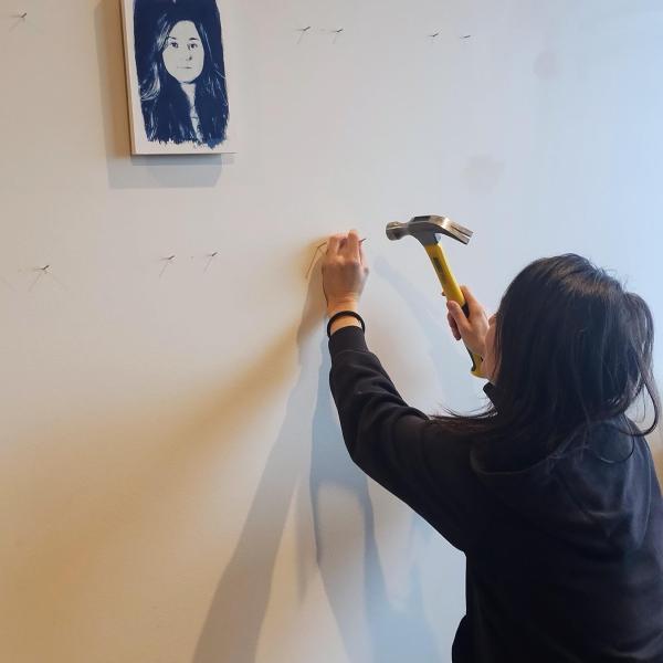 Tarah Dowling hangs her photographs on the wall of the View Gallery.