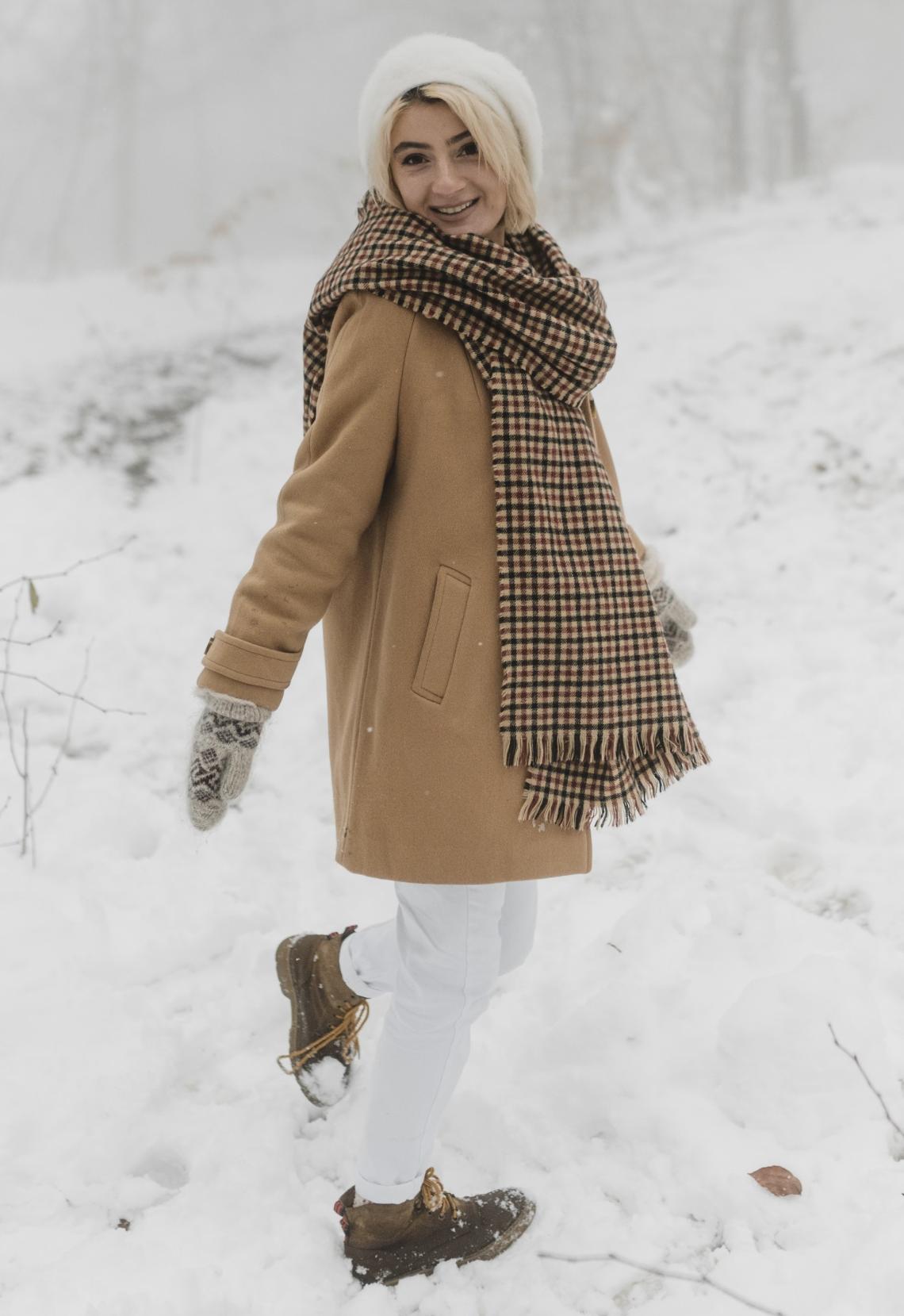 Woman wearing toque, mittens and winter jacket