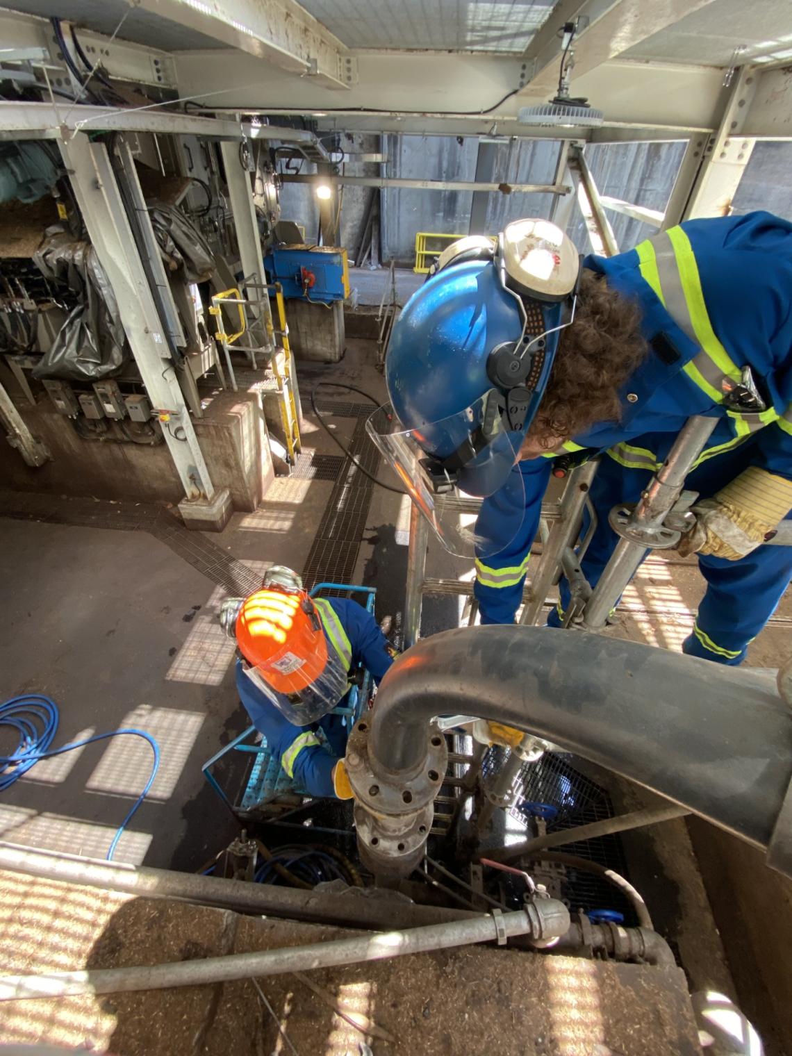 Power engineers work on a pipeline inside a facility