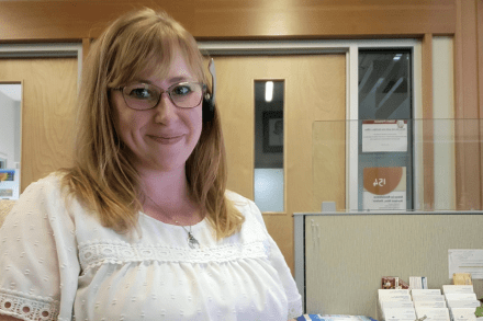 Amanda Rozenboom sitting at her work desk and smiling at the camera