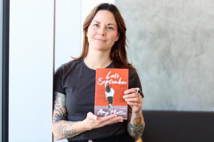 Amy Mattes holds up a copy of her book, Late September.