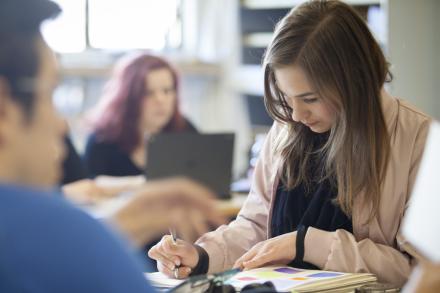 female student writing in notebook