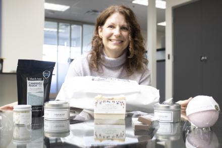 Angela poses with the ingredients of the self-care grad box