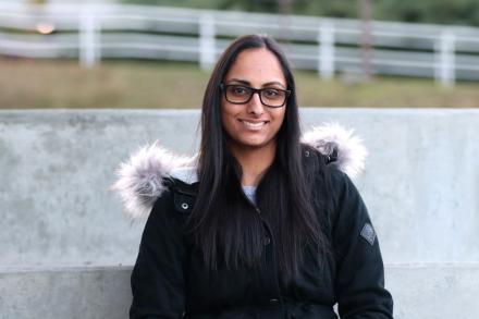 Portrait of Nina Gill sitting and smiling at the camera