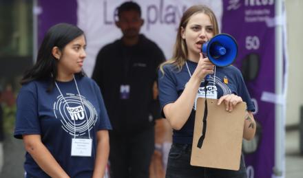 Two students wearing RockVIU shirts, one holding a loudspeaker