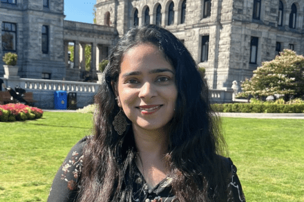 Harleen Kalra standing outside on a sunny day and smiling at the camera.