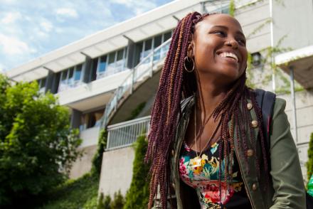 student smiling outside of library