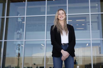 Teagan stands outside the glass windows on the Centre for Health and Science at VIU's Nanaimo campus