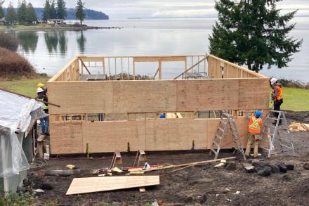 Students frame up a home with an ocean view in the background