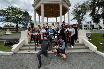 a group holding paddles poses for a photo