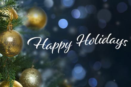 Happy holidays in text with background of ornaments on a tree